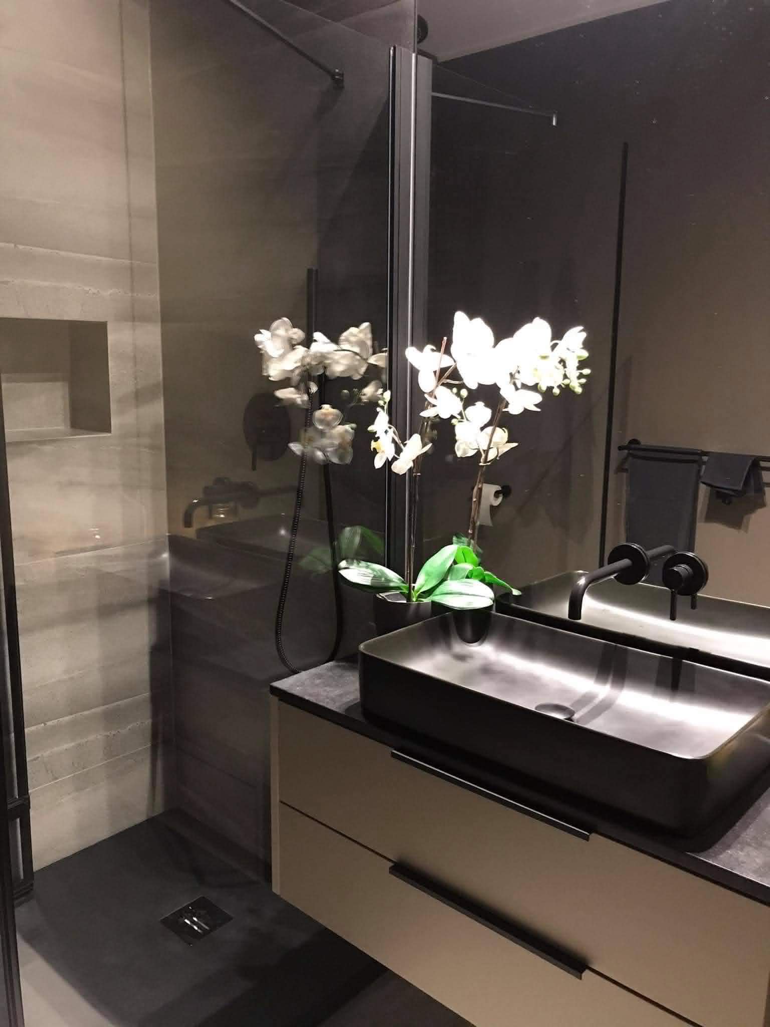 Dark bathroom overview with walk-in shower and floating vanity