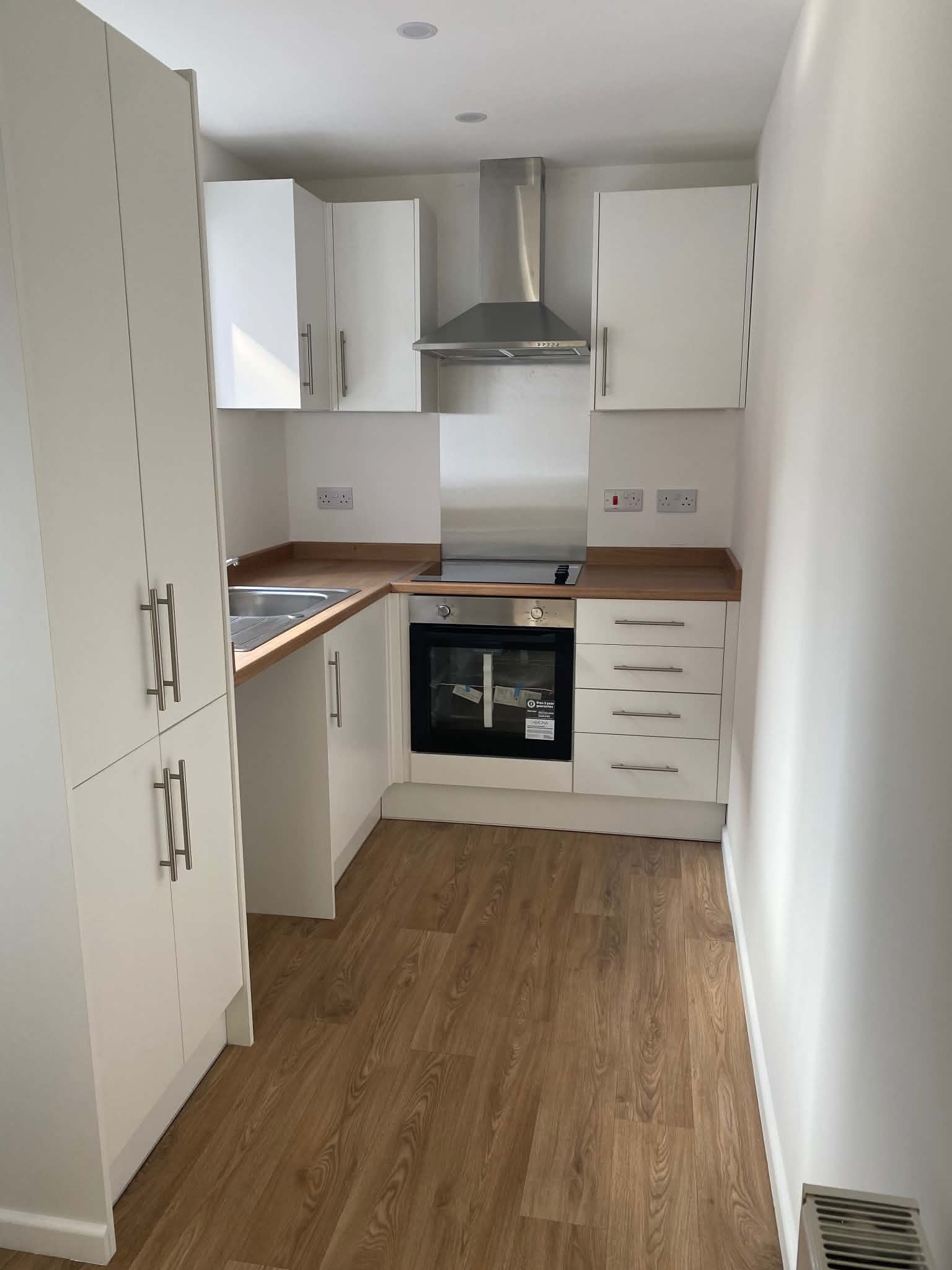 White fitted kitchen with oak worktops and wood flooring, Durham